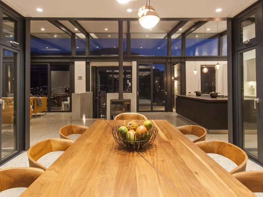Timber dining table in a glass-walled living space, Lion's Head and Fresnaye